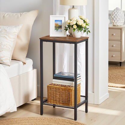 Small side table with a lamp, books, and flowers in a bedroom setting.