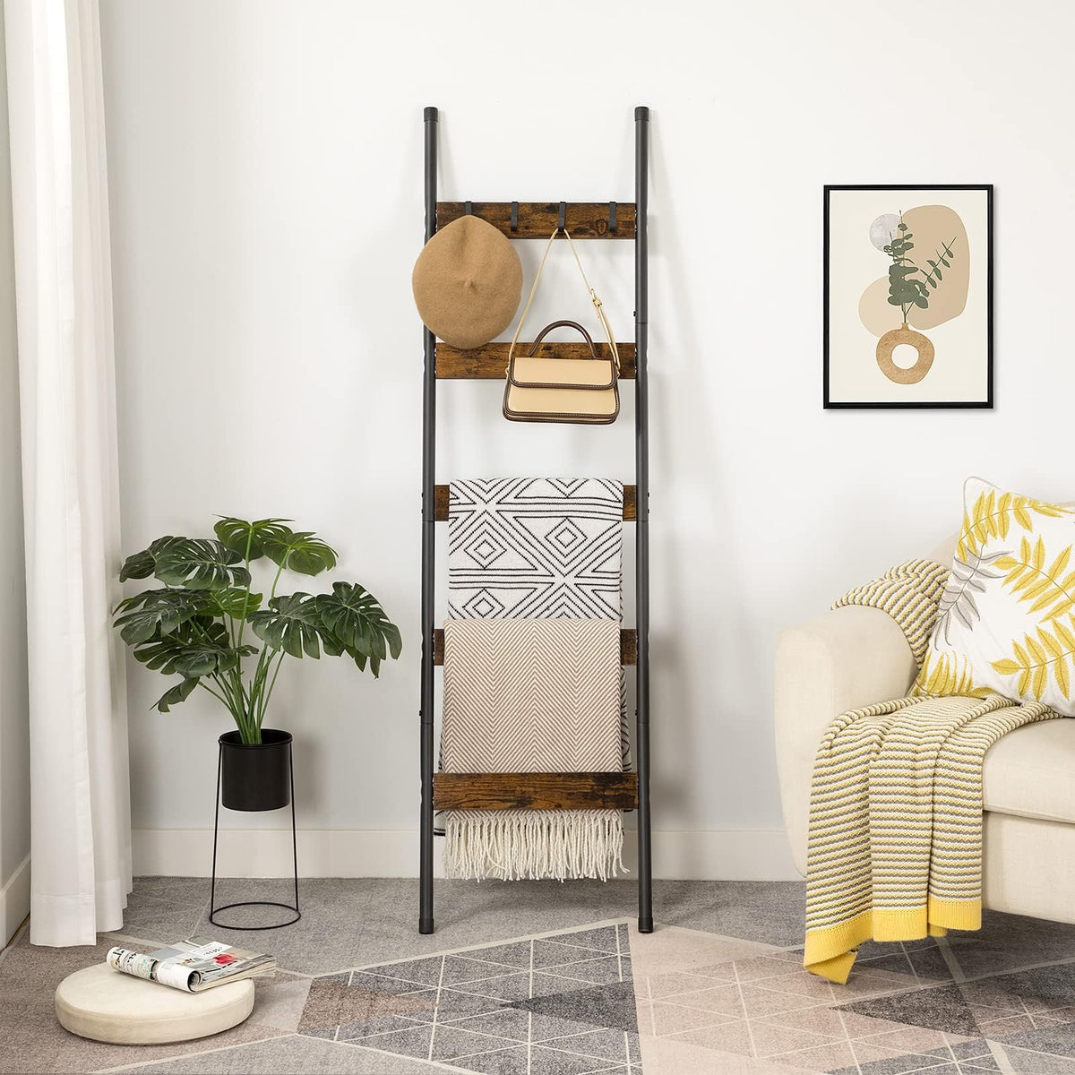 Rustic brown blanket ladder shelf leaning against a living room wall holding throws, a hat, and a handbag.